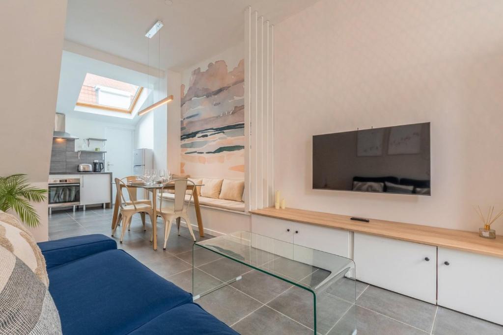 a living room with a blue couch and a table at Maison 3 chambres, parking gratuit & proche métro in Croix