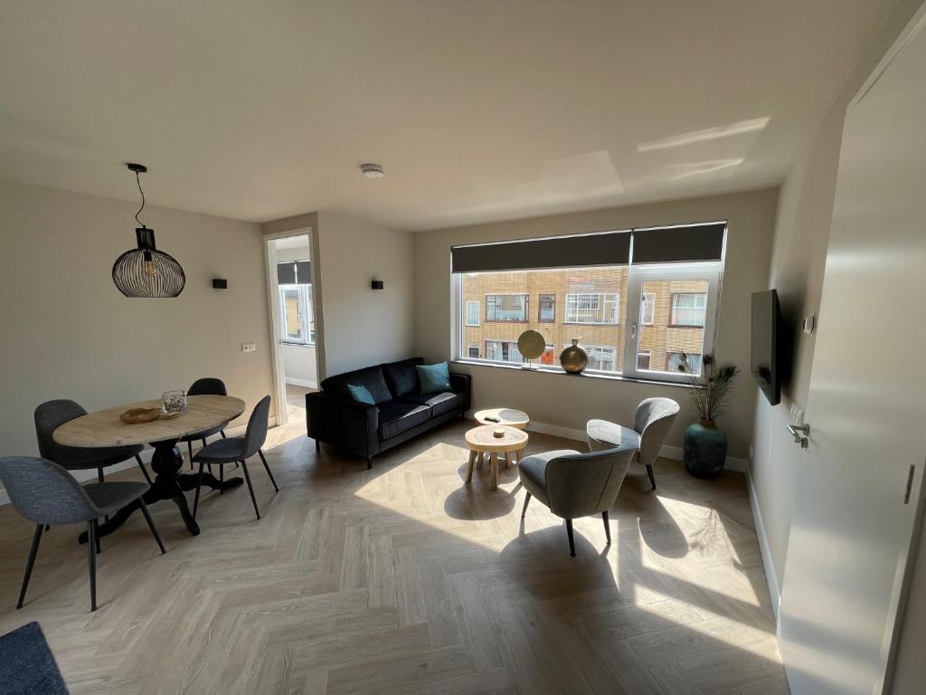 a living room with a table and a couch at Familie appartement Katwijk aan zee 1 in Katwijk aan Zee