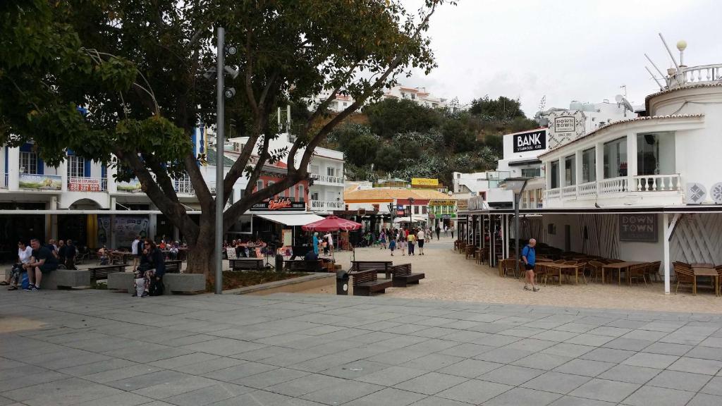 a group of people walking around a street with buildings at Studio near the beach in Albufeira