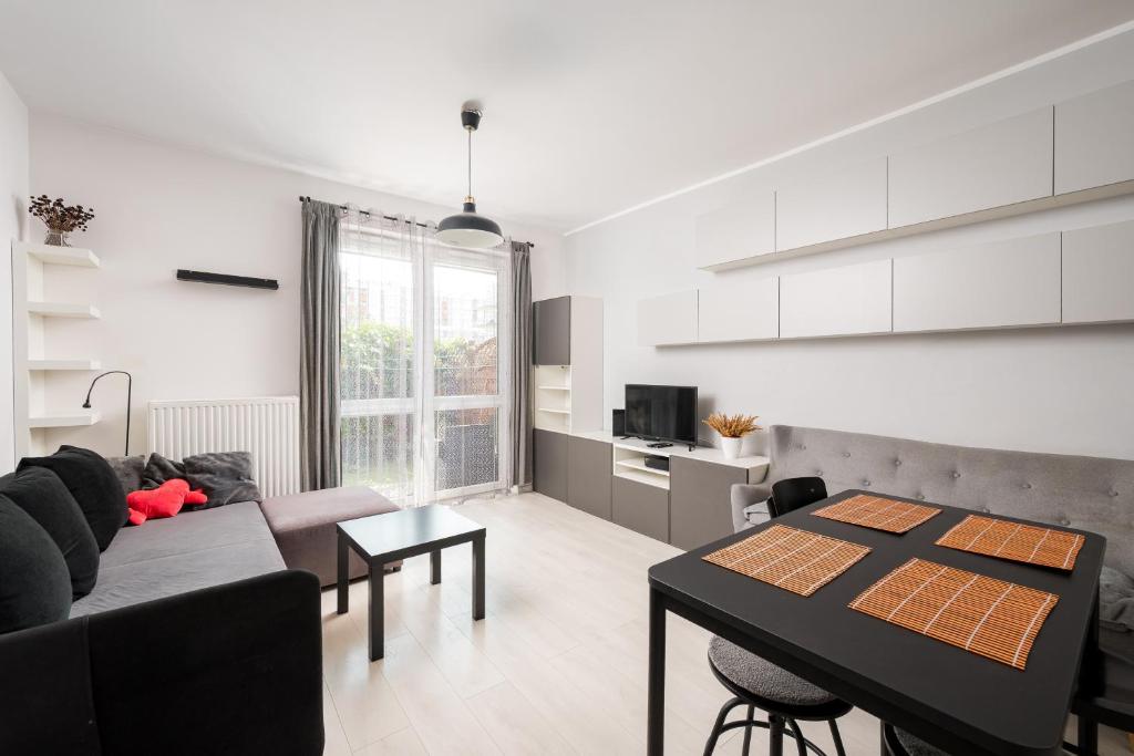 a living room with a couch and a table at Bemowo Homely Apartment by BookingHost in Warszawa