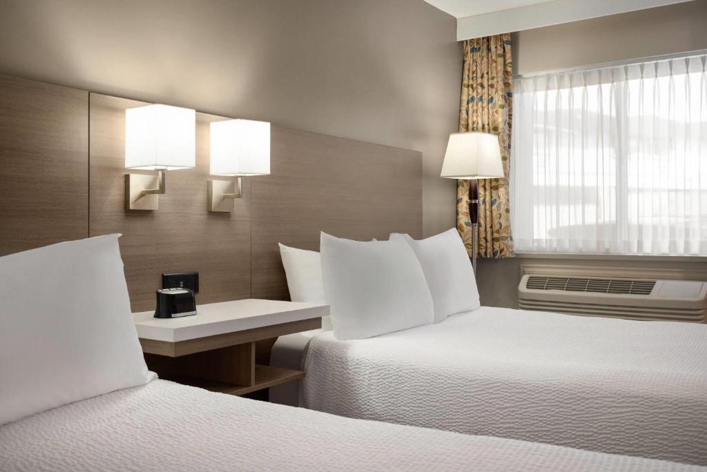 Postel nebo postele na pokoji v ubytování Days Inn by Wyndham Kelowna