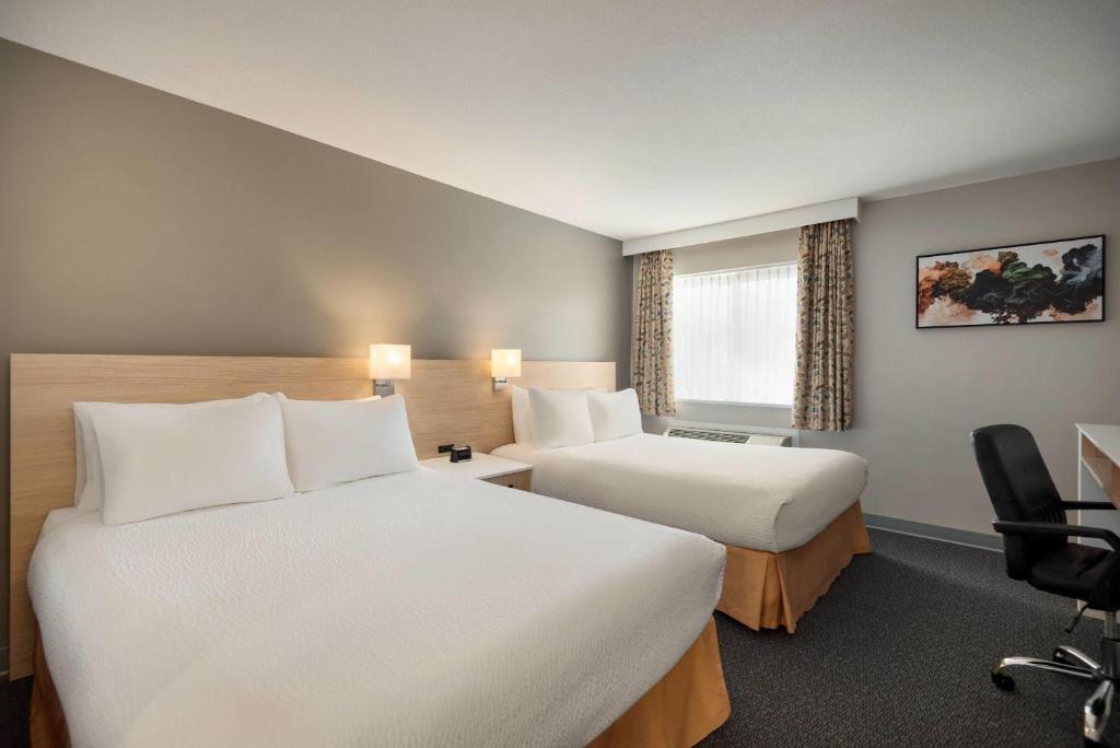 Postel nebo postele na pokoji v ubytování Days Inn by Wyndham Kelowna