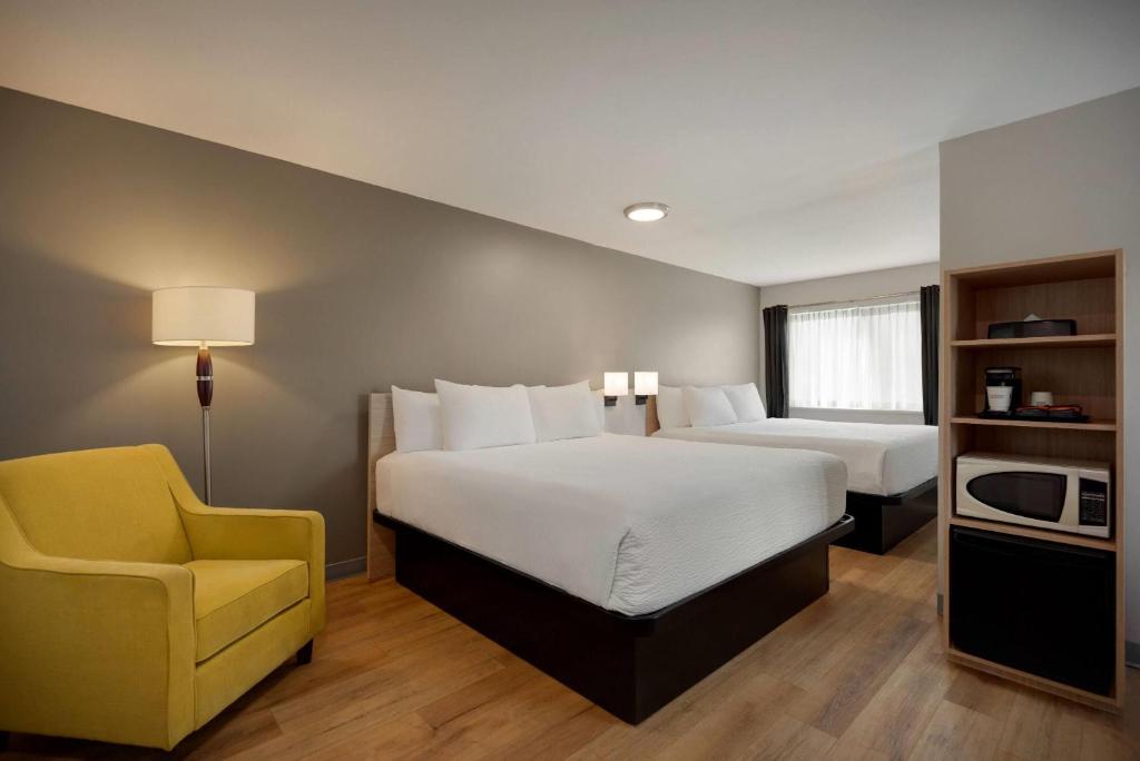 Postel nebo postele na pokoji v ubytování Days Inn by Wyndham Kelowna
