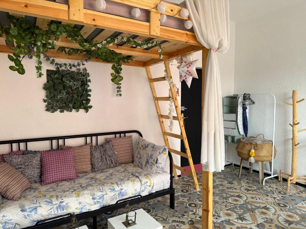 a living room with a couch under a loft bed at Cosy studio Gueliz in Marrakech