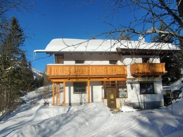 ein Haus mit schneebedecktem Dach im Schnee in der Unterkunft Apartment Leber in Ehrwald