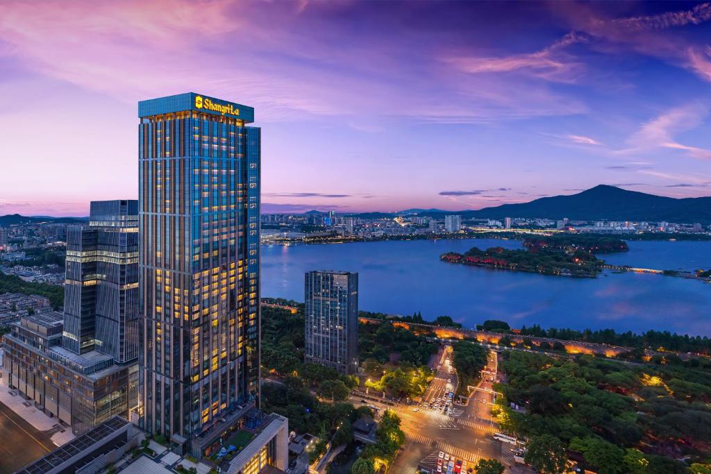 a tall building next to a large body of water at Shangri-La Nanjing in Nanjing