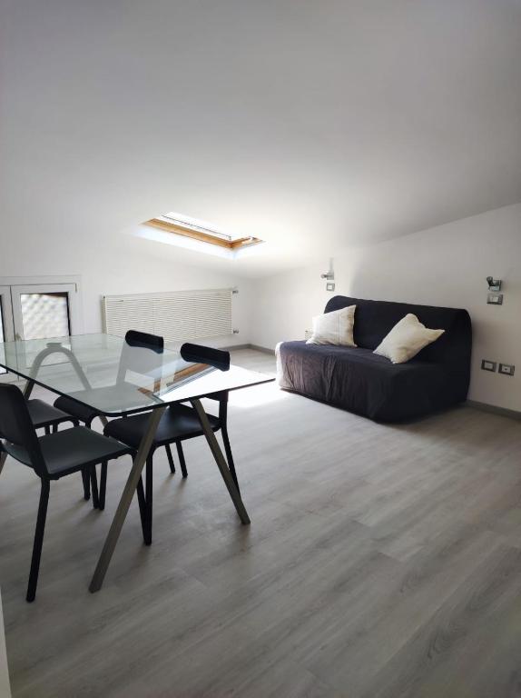a living room with a glass table and a couch at La mansarda del Panfilo in Cervia