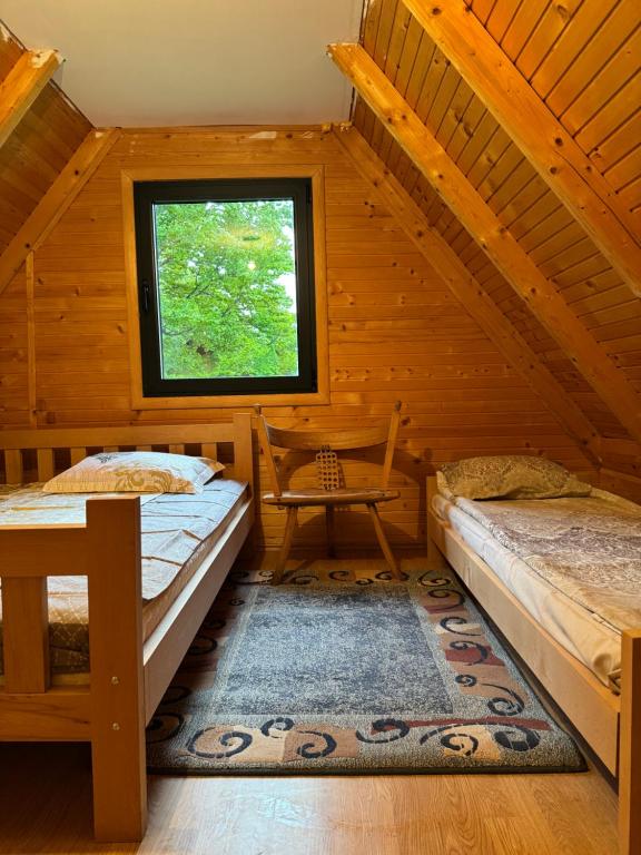 ein Schlafzimmer mit zwei Betten in einer Blockhütte in der Unterkunft Hideaway with a view in Žabljak