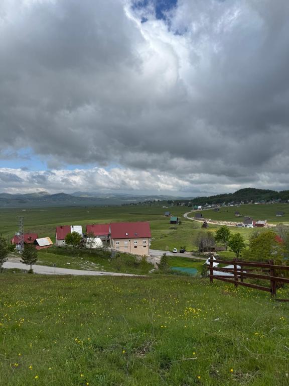 Blick auf einen Bauernhof mit einem Zaun und einem Feld in der Unterkunft Hideaway with a view in Žabljak