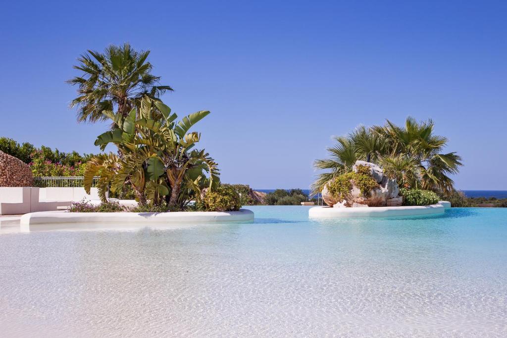 two islands in the water with palm trees at Relais Masseria Caselli in Carovigno