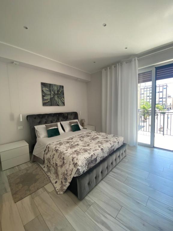 a bedroom with a large bed and a large window at Casa Letizia Pescara Centro in Pescara