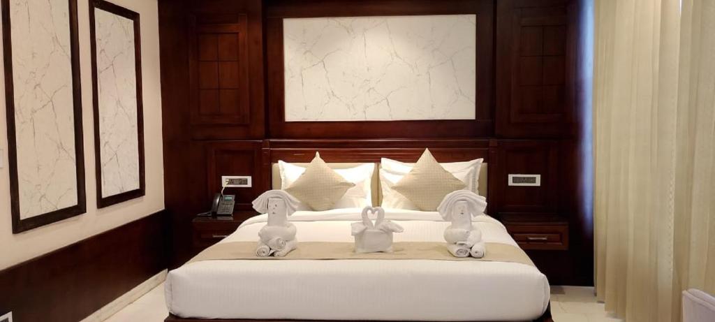 a bedroom with a bed with two rabbits on it at Hotel YKM Crown in Dehradun