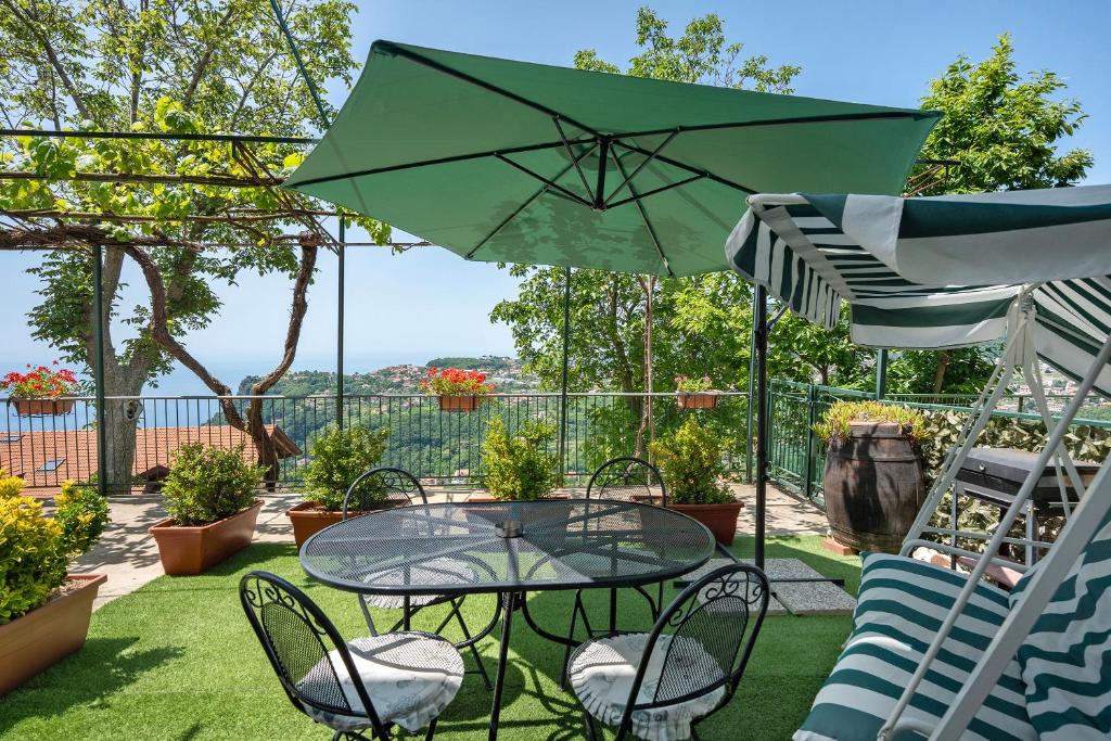 un patio con tavolo, sedie e ombrellone di Bella veduta Luna ad Agerola