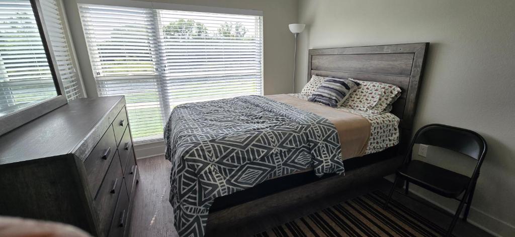 Un dormitorio con una cama y una cómoda y una ventana. en Furnished Executive 3-bed 2-bath Apartment Wichita Kansas, en Wichita
