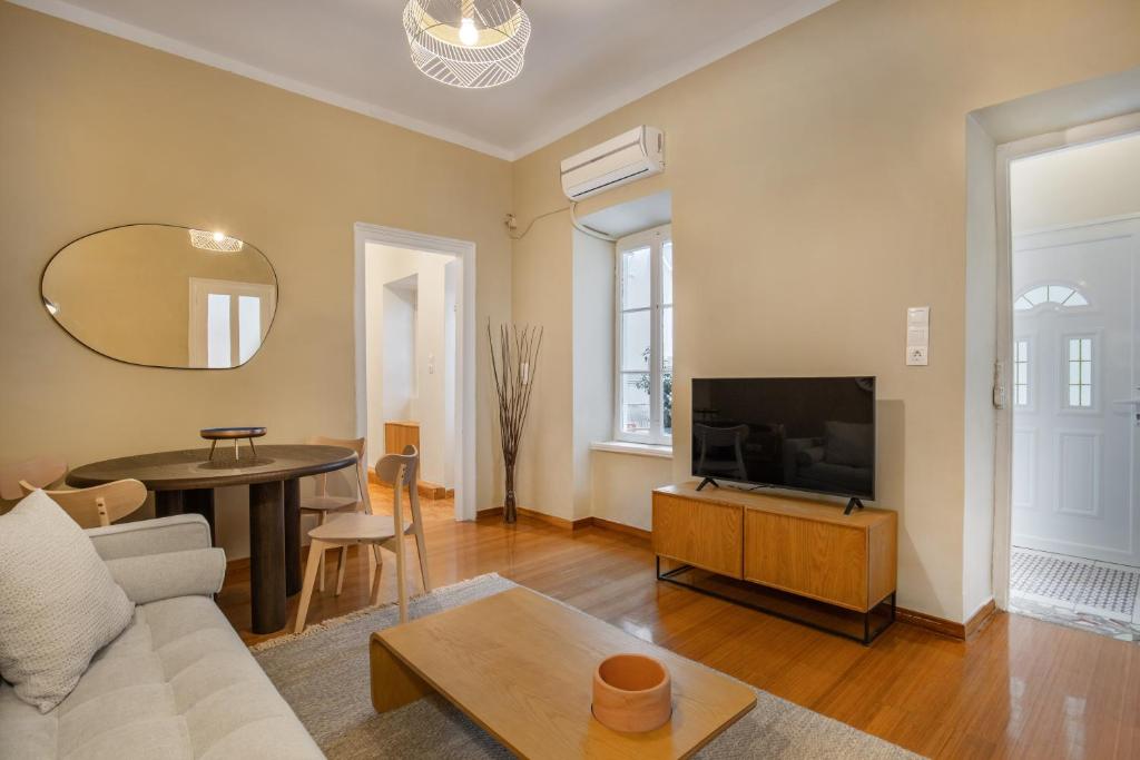uma sala de estar com um sofá, uma TV e uma mesa em Grand Haven - New Renovated Spacious Apts in Prime Location em Atenas