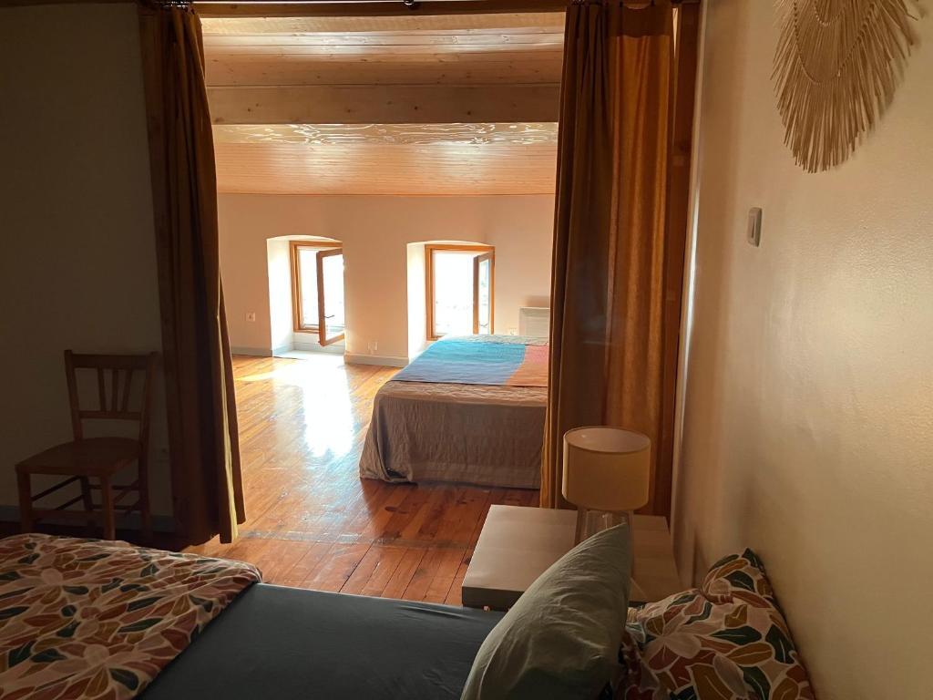 - une vue sur une chambre avec un lit et un miroir dans l'établissement Les Bleuets, à Saint-Andéol