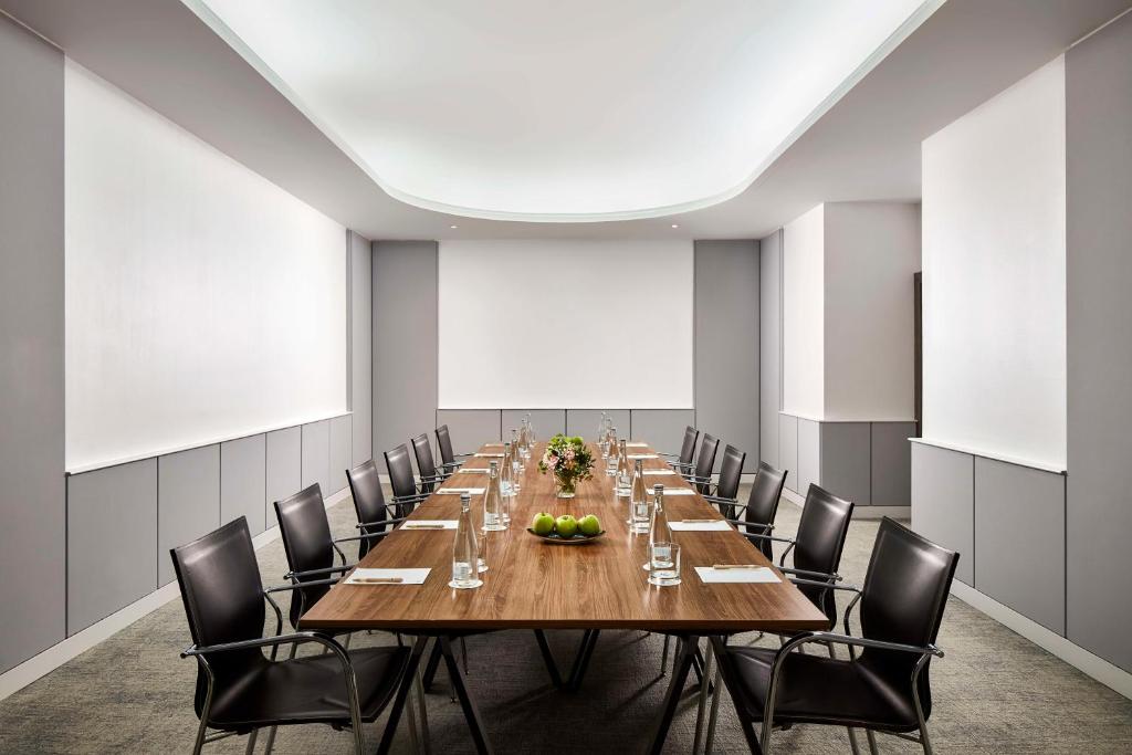 A formal conference room set up around one long boardroom table.