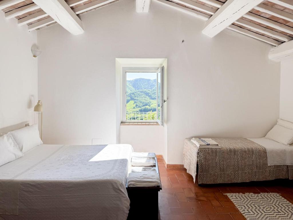 a white room with two beds and a window at AGRITURISMO BUON VENTO, Appartamento PICCOLI SOLI una chic country house in Gubbio Italy in Gubbio