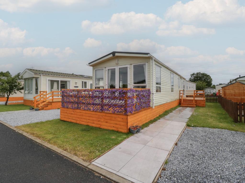 a manufactured home with a deck and a house at Willow in Denny