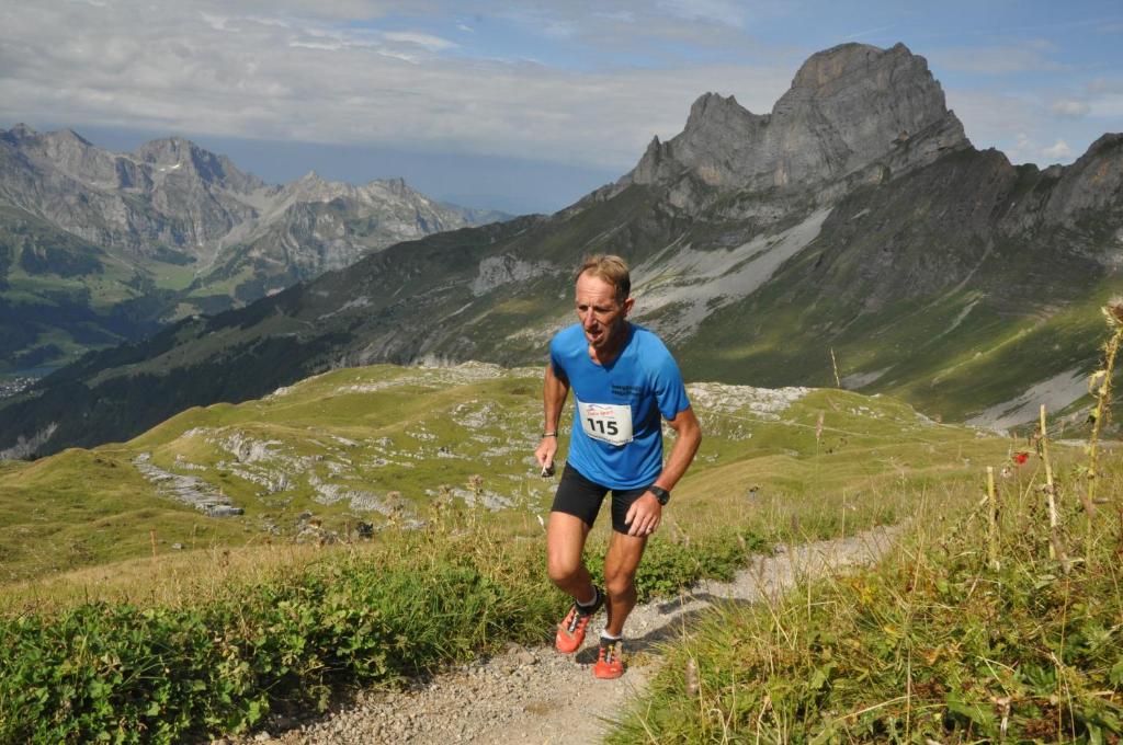 a man running on a trail in the mountains at Hotel Engelberg "mein Trail Hotel" in Engelberg