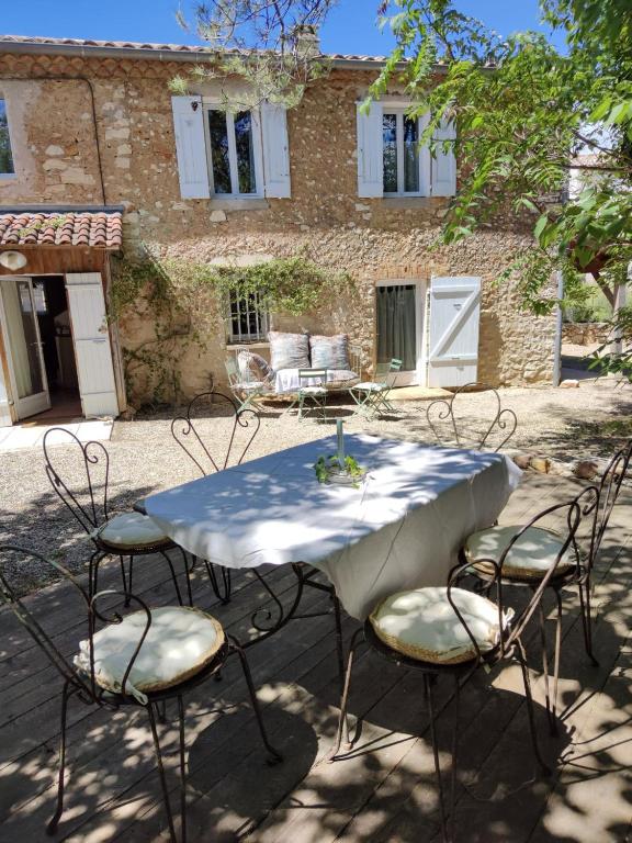 une table et des chaises devant un bâtiment dans l'établissement La Verrerie, à Seillons-Source-dʼArgens