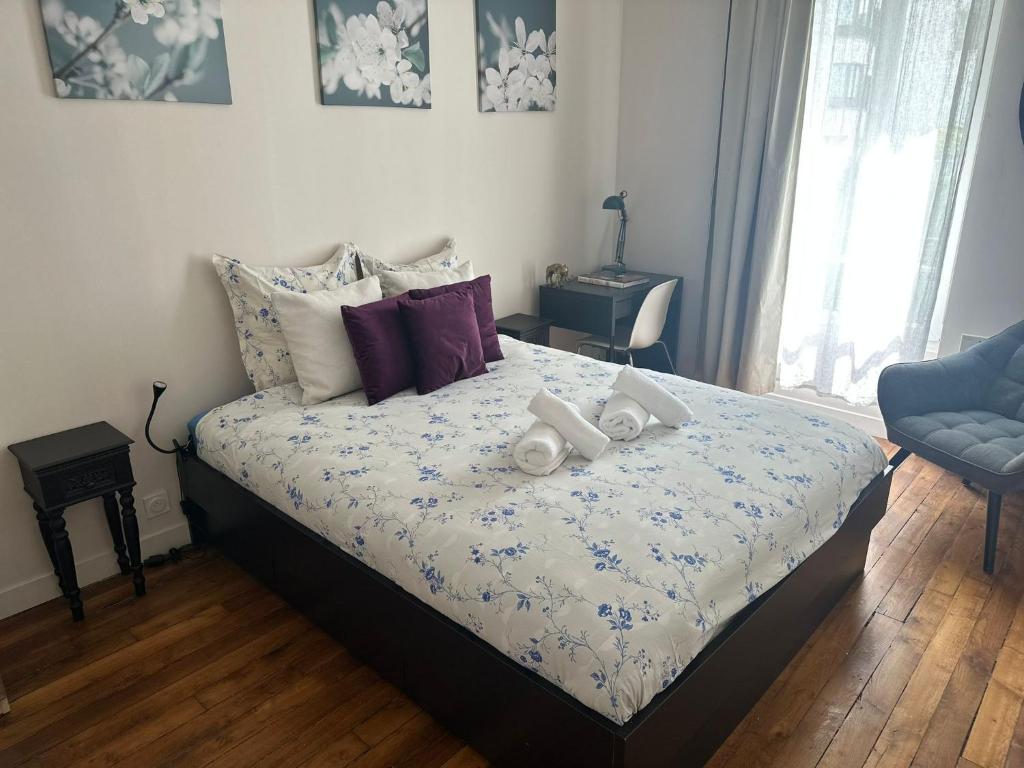a bedroom with a bed with towels on it at Lumineux & cosy accès Paris Versailles La Défense in Suresnes
