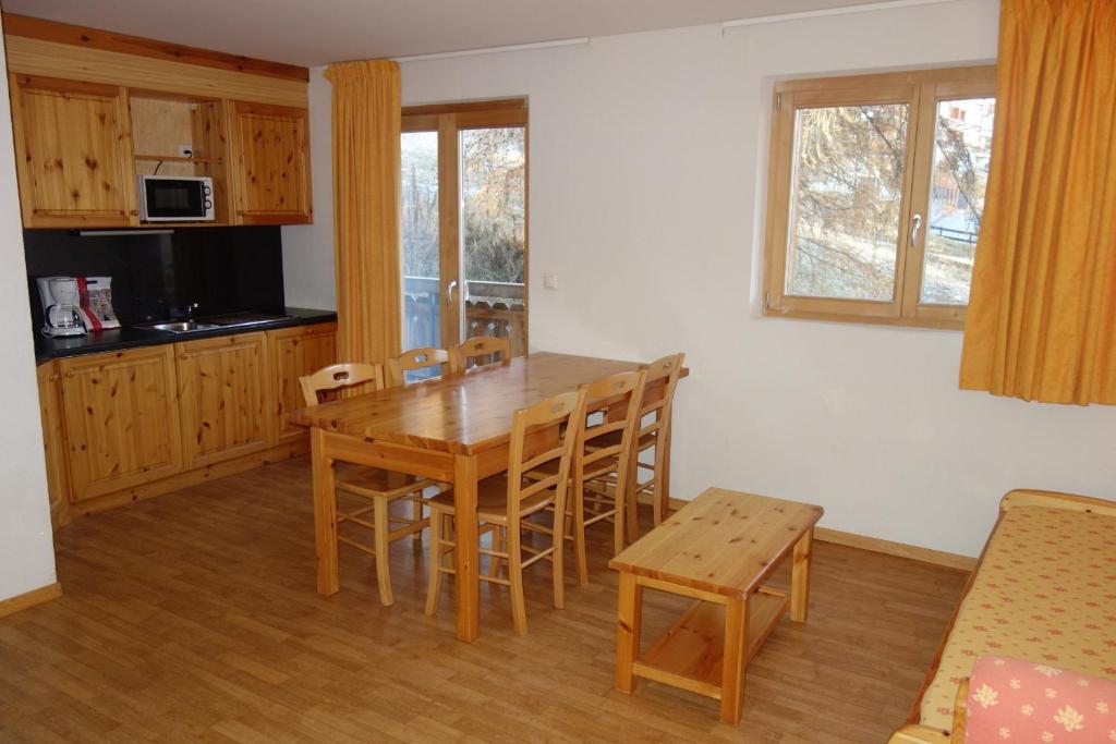 una cucina e una sala da pranzo con tavolo e sedie in legno di Pracondu 1 405 - OUTDOOR & FUN apartment 6 pers a Nendaz