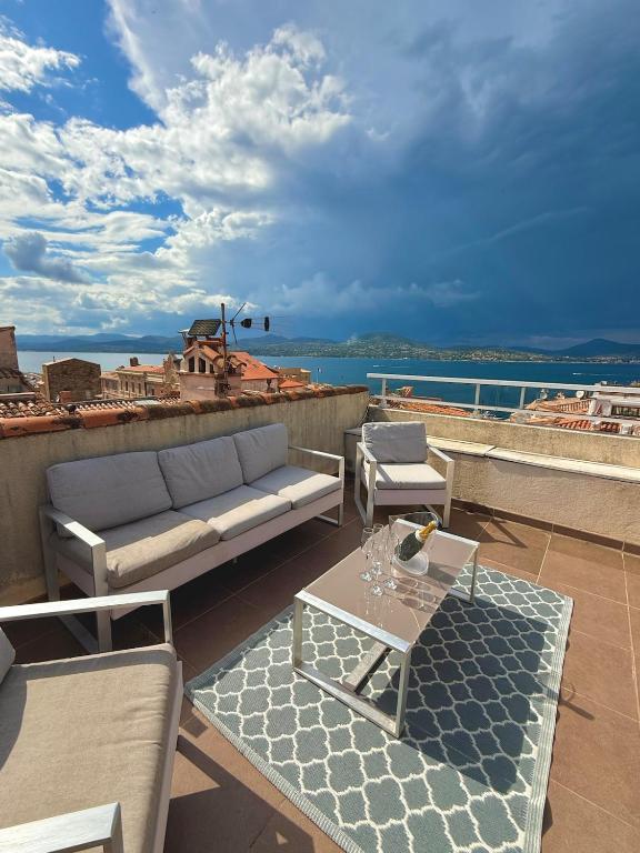 un patio avec un canapé et une table sur le toit dans l'établissement Sur le toit de Saint-Tropez, à Saint-Tropez