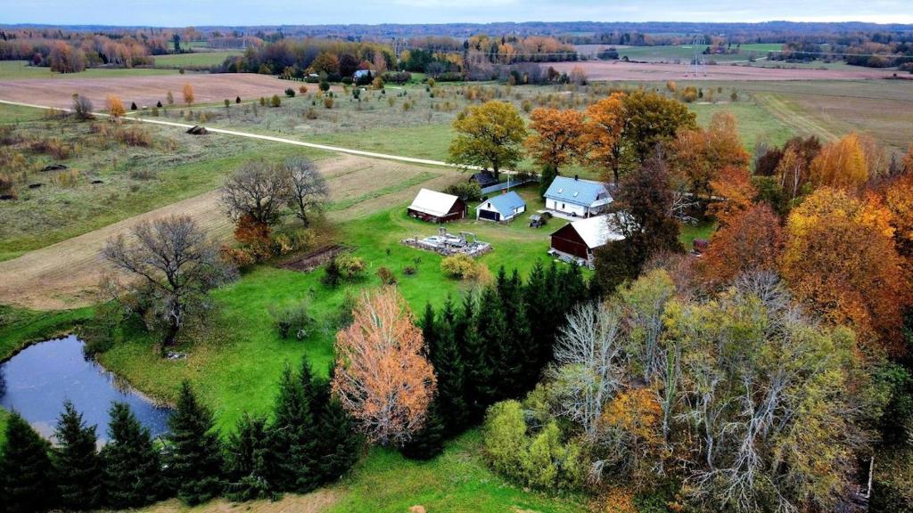 eine Luftansicht eines Bauernhofs mit einem Haus und einem Teich in der Unterkunft Cozy, private country home with a garden and sauna 