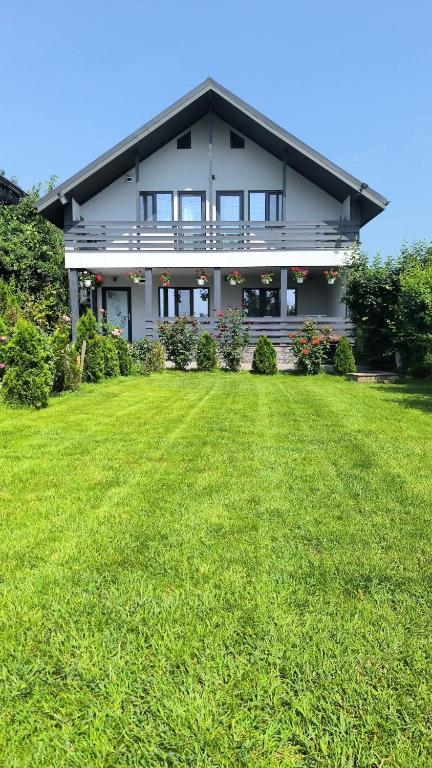 a house with a large lawn in front of it at Casa Berbec2 in Dealul Viei