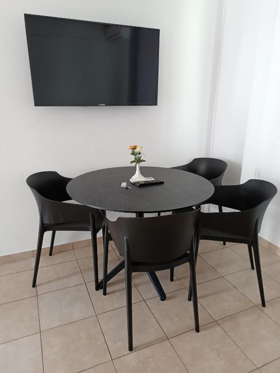 a black table with black chairs and a tv at Georgia Hotel Apartments in Protaras