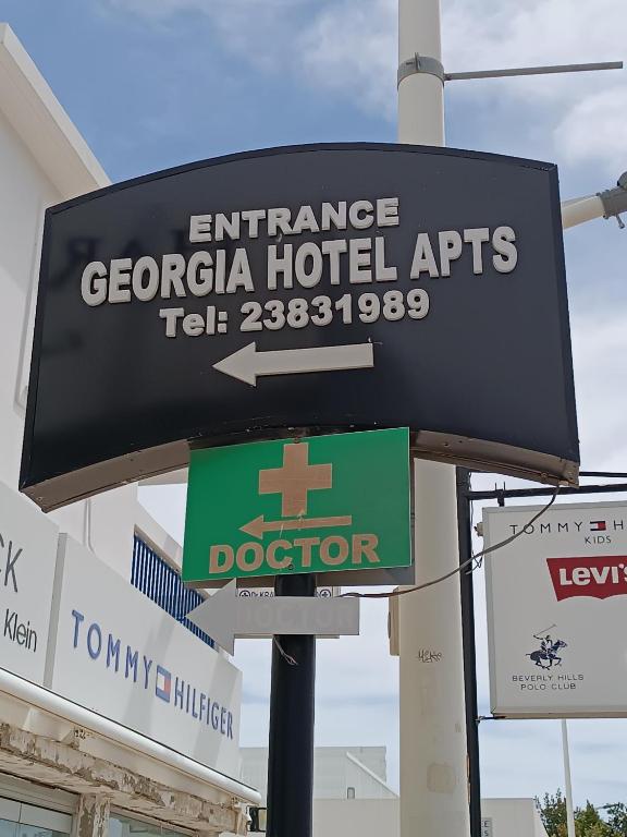 a sign for an entrance to aaciacco hotel arts at Georgia Hotel Apartments in Protaras