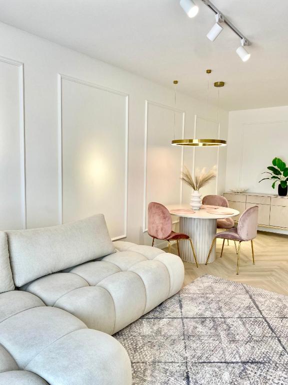 a living room with a couch and a table at Apartament DeLuxe Zamość Prywatny parking podziemny in Zamość