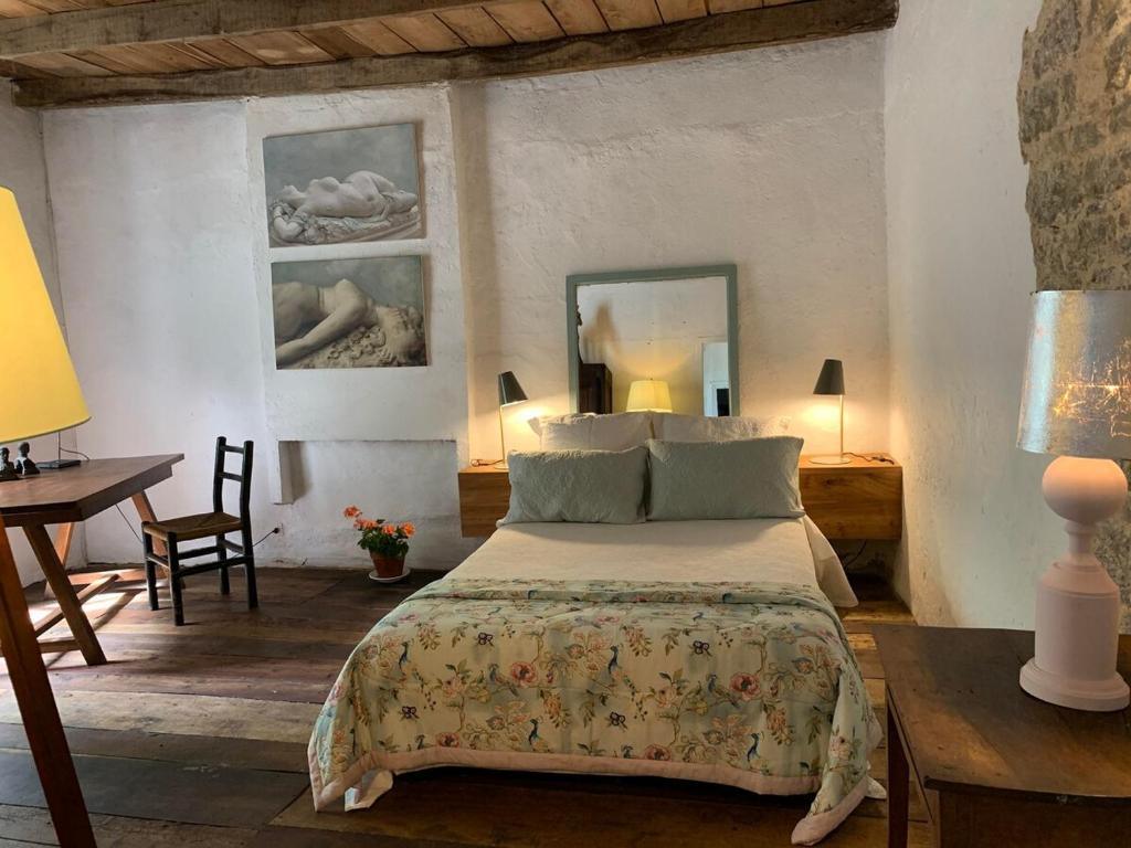 ein Schlafzimmer mit einem Bett, einem Tisch und einem Schreibtisch in der Unterkunft The Guardians Cottage, Chateau Mas de Pradie in Foissac