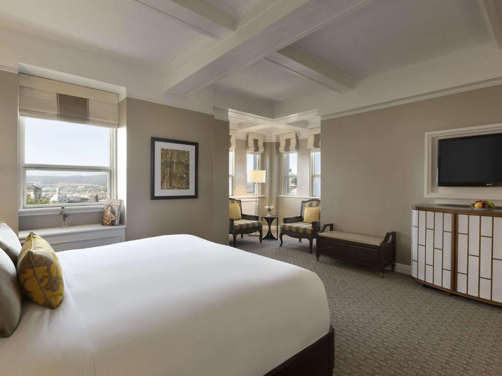 a hotel room with a large bed and a flat screen tv at Fairmont Le Chateau Frontenac in Quebec City