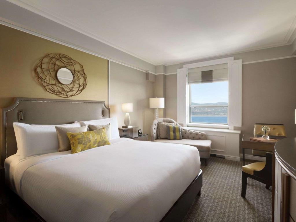 a hotel room with a large bed and a window at Fairmont Le Chateau Frontenac in Quebec City