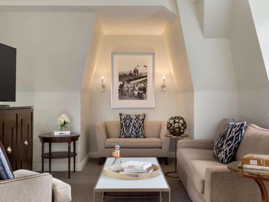 a living room with two couches and a table at Fairmont Le Chateau Frontenac in Quebec City