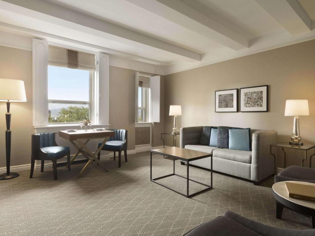 a living room with a couch and a table at Fairmont Le Chateau Frontenac in Quebec City