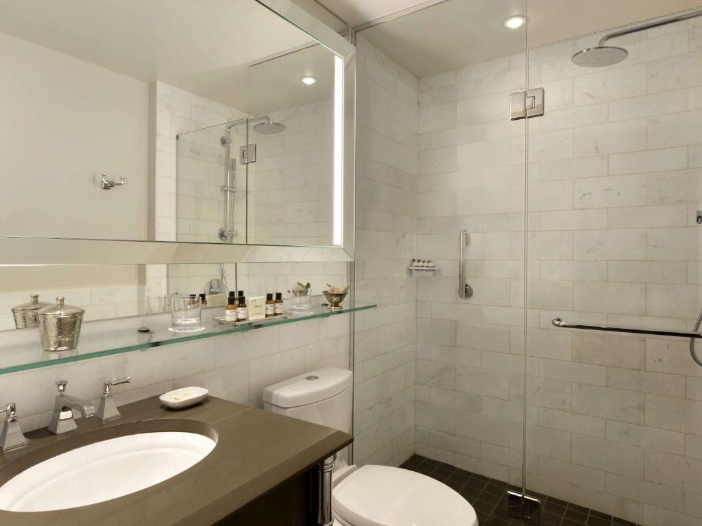 a bathroom with a toilet and a sink and a shower at Fairmont Le Chateau Frontenac in Quebec City