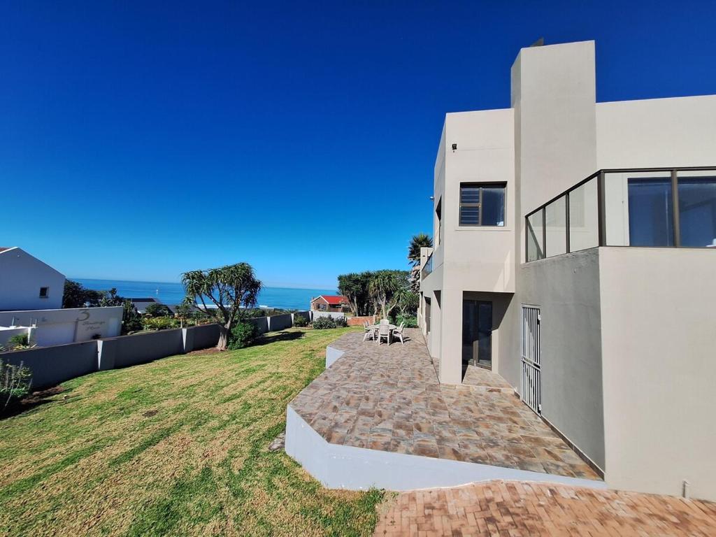 a white house with a pathway leading to a yard at Barefoot Bliss Holiday Home in Port Alfred