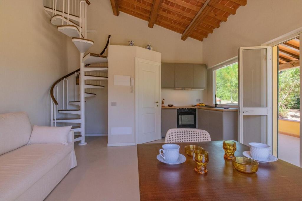 a living room with a couch and a spiral staircase at Farmhouse by the sea - Grilli 3 in Lacona
