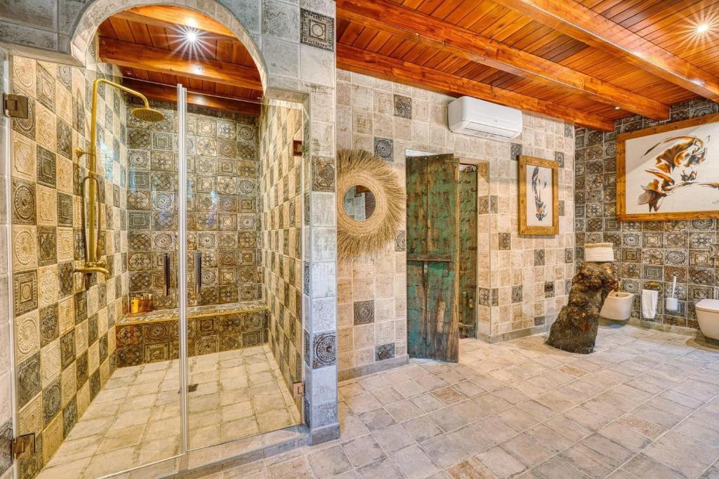 a tiled bathroom with a shower and a toilet at Cortijo Boutique Marbella in Marbella