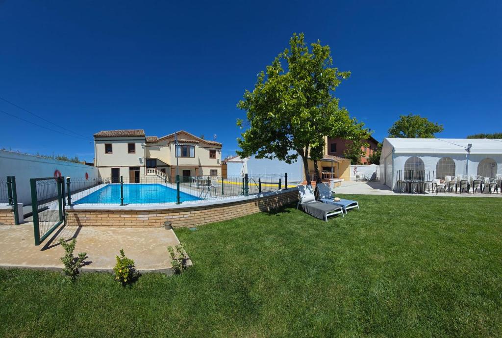 un patio con una casa y una piscina en La Huerta Corella, en Corella