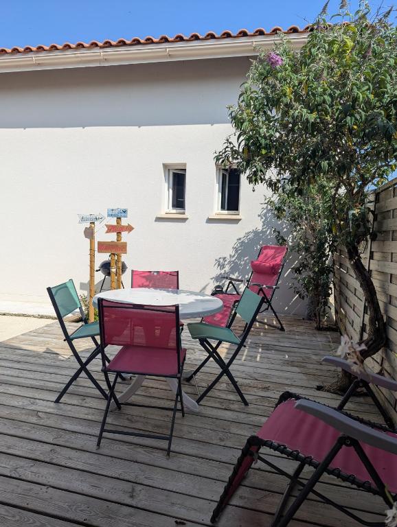a group of chairs and a table on a deck at Chez les Martin in Castelnau-de-Médoc