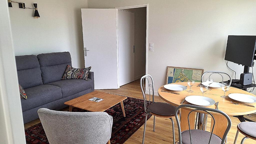 un salon avec une table et un canapé dans l'établissement Duplex face à la gare Arcachon, à Arcachon