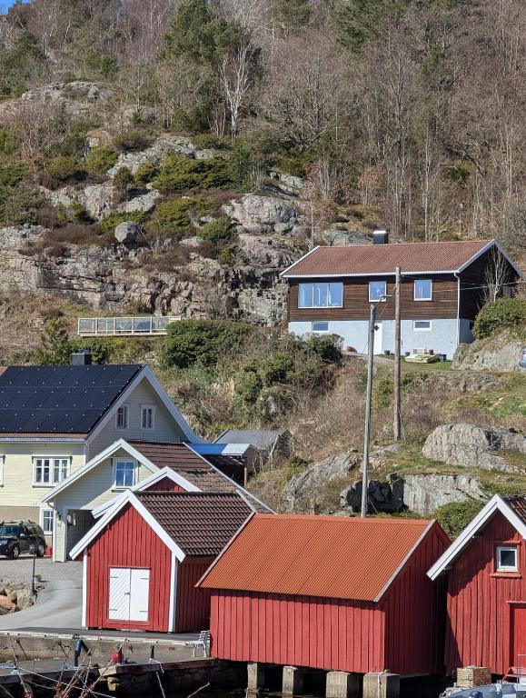 a group of buildings and houses on a hill at Flott hytte skjærgård Lindesnes in Svinøy