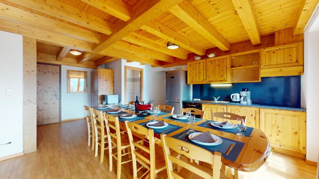 a large kitchen with a long table and chairs at Pracondu 2 502 - OUTDOOR & FUN charming apartment in Nendaz