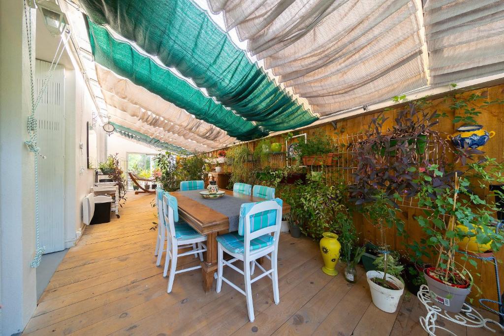 un patio avec une table, des chaises et des plantes dans l'établissement Riviera d'Ax - proche télécabine Ax 3 Domaines, à Ax-les-Thermes