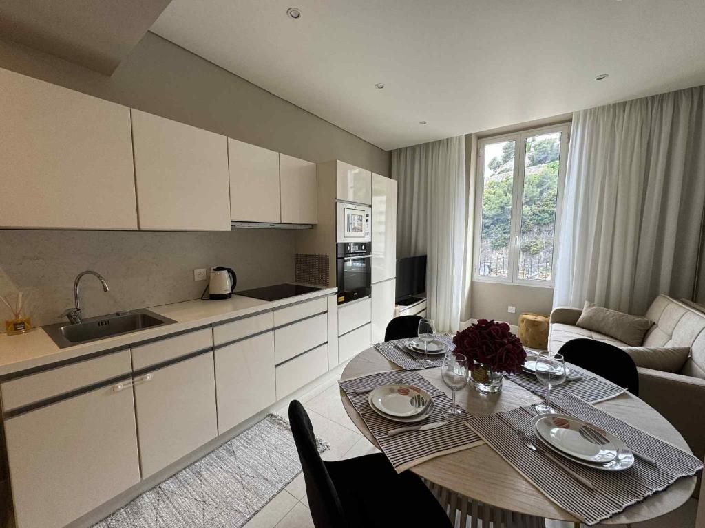 une cuisine et un salon avec une table, une cuisine et une salle à manger dans l'établissement Joli appartement 2 pièces à 5 min de Monaco, à Beausoleil