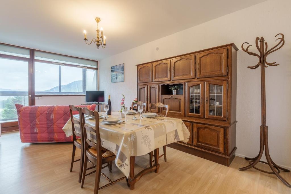 une salle à manger avec une table et un canapé dans l'établissement Le Chitelet 506 - Au pied des pistes, à La Bresse